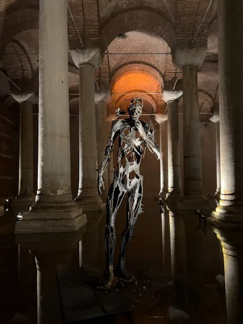 Sculpture métallique se reflétant dans bassin souterrain entre colonnes à San Gimignano