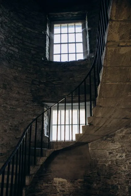 Escalier en colimaçon en pierre et fenêtres à barreaux d'une tour de San Gimignano