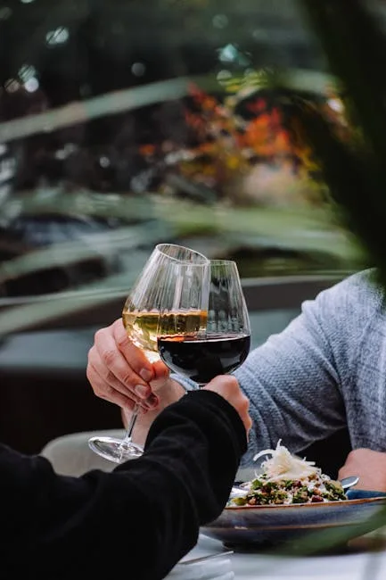 Deux convives trinquent avec vin blanc et rouge, terrasse à San Gimignano