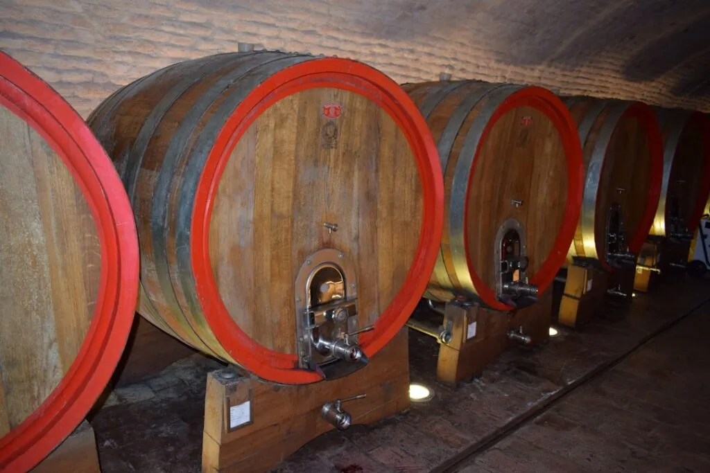 Fûts de bois alignés dans une cave à vin typique près de San Gimignano