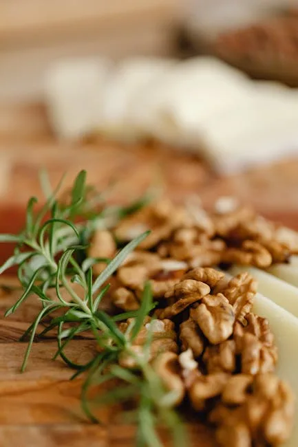 Plan rapproché de noix et fromage sur planche, brin de romarin