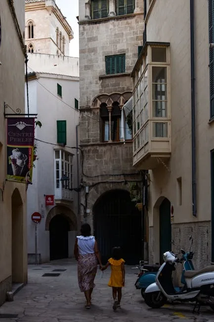 Mère et enfant main dans la main traversant une ruelle étroite