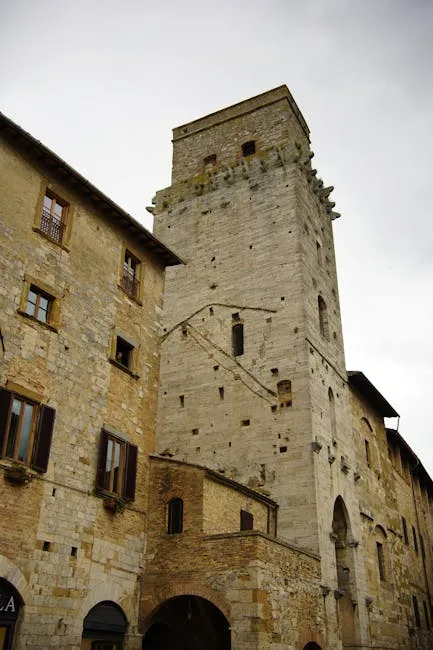Tour médiévale en pierre dominant une rue étroite à San Gimignano
