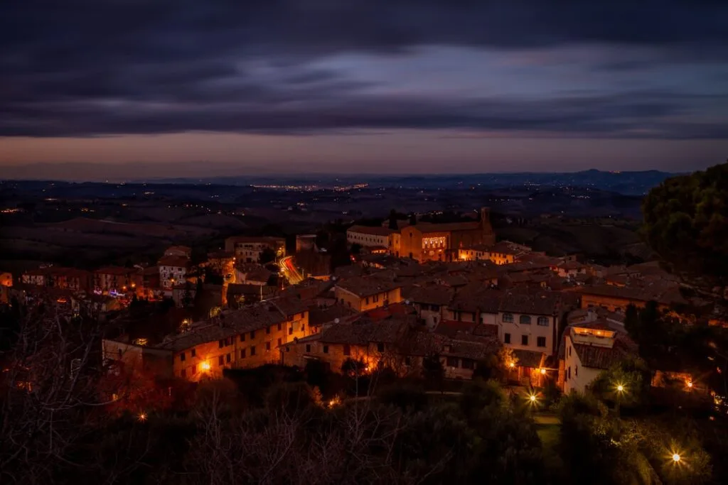vue nocturne de San Gimignano illuminée, collines toscanes en arrière-plan