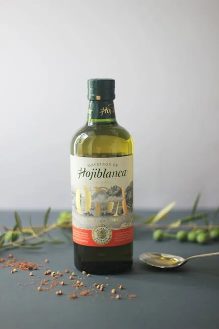 Bouteille d'huile d'olive Hojiblanca posée avec cuillère et olives