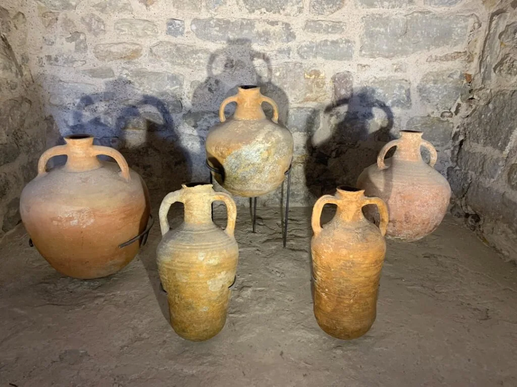 Amphores en terre cuite alignées dans une cave médiévale de San Gimignano