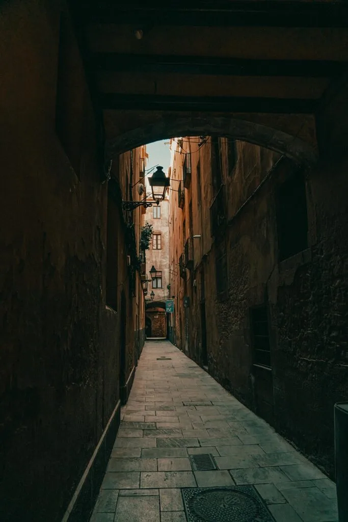 Allée étroite et voûtée bordée de façades anciennes